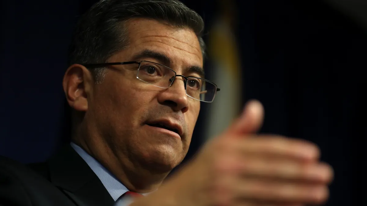 HHS Secretary Xavier Becerra speaks to reporters.