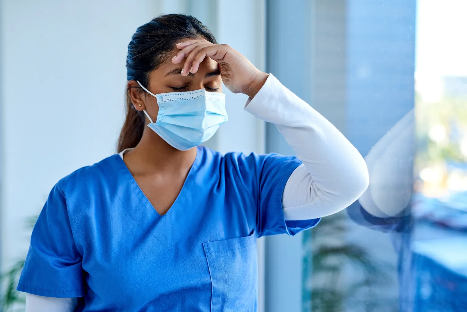 Shot of a masked young doctor looking distressed.