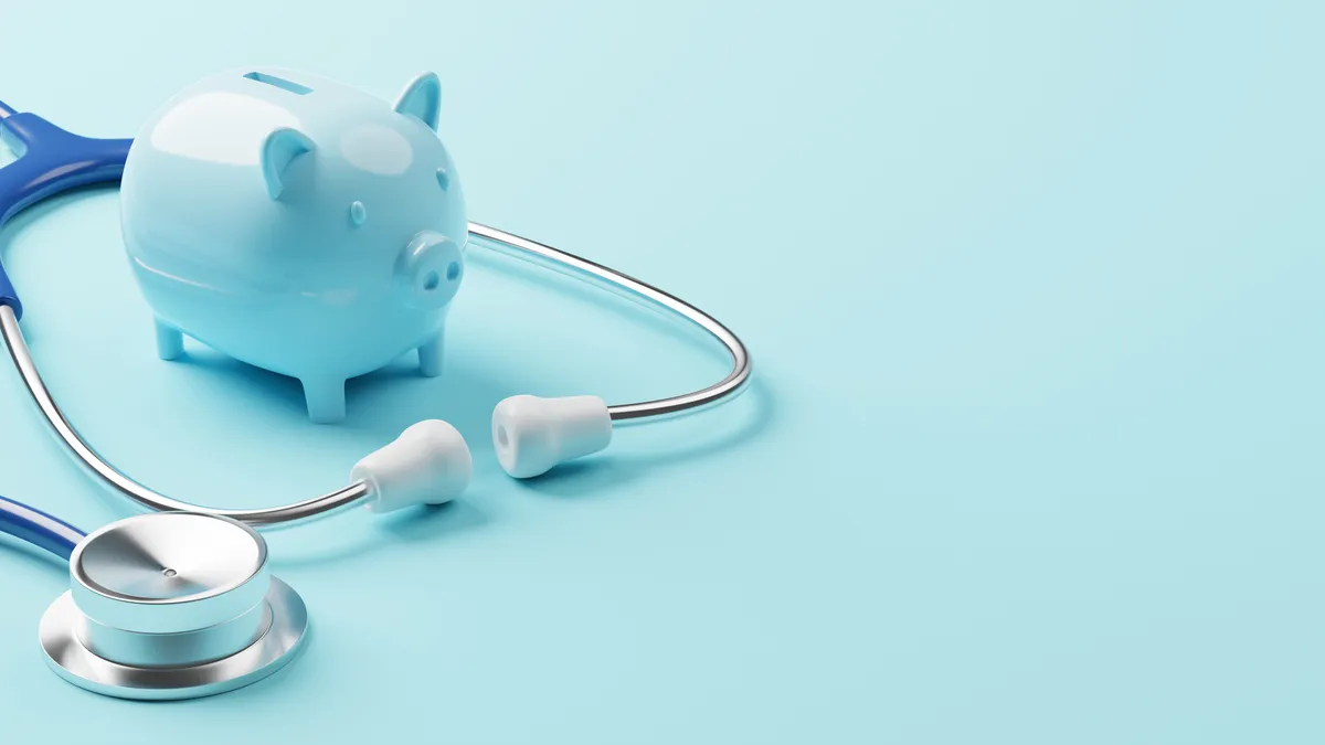 A piggy bank rests near a stethoscope.