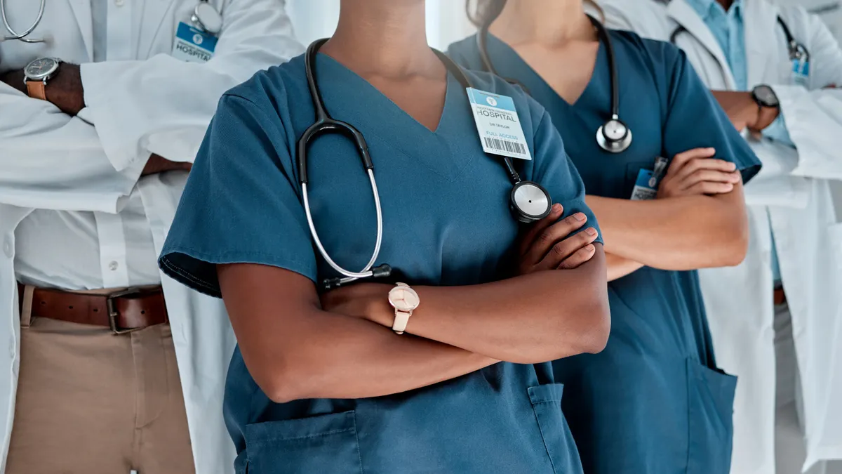 Group of doctors standing with their arms crossed while working at a hospital.