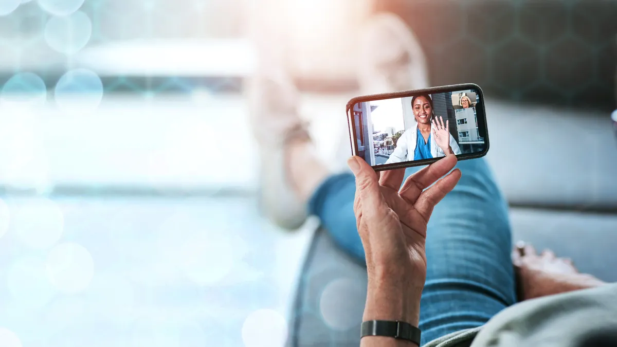 A person greeting their doctor through a mobile phone screen.