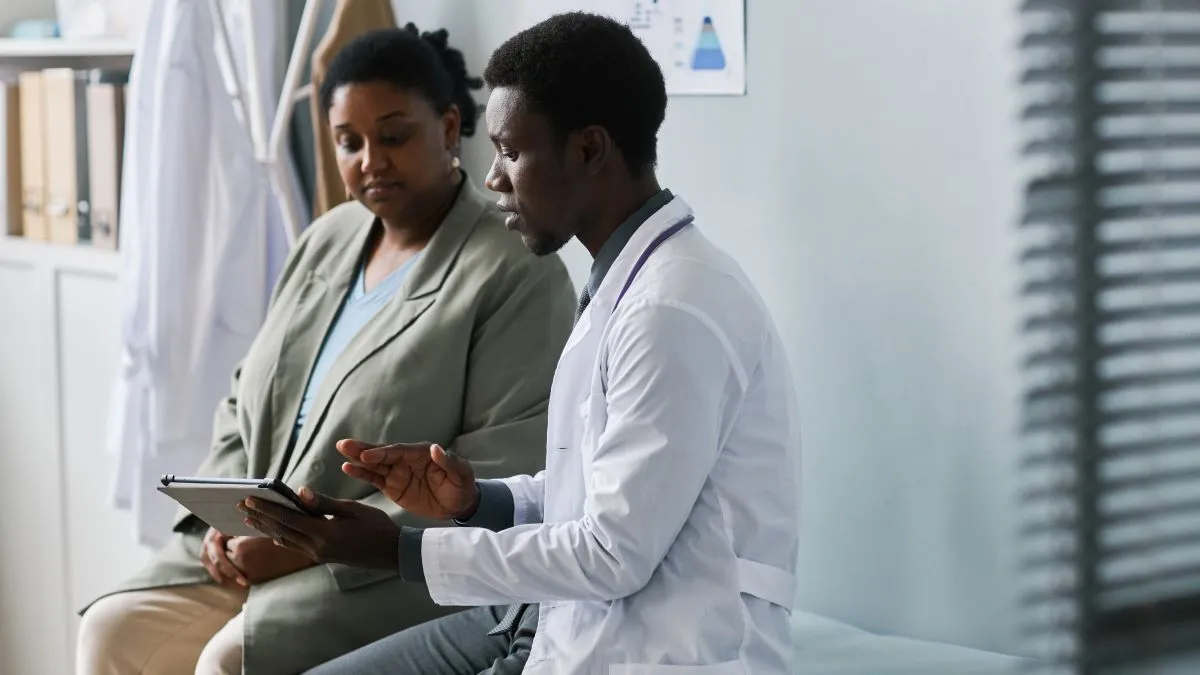 Side view portrait of doctor and patient talking in a clinic setting.