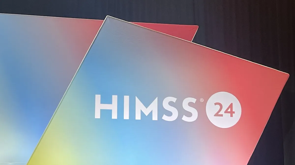 The HIMSS logo is seen on a multicolored backdrop onstage.